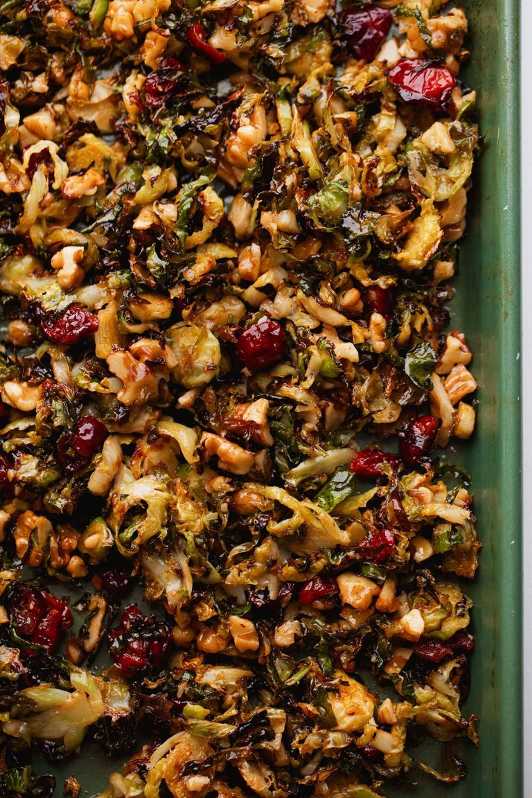 Brussels sprouts on a sheet pan with cranberries and gochujang butter.