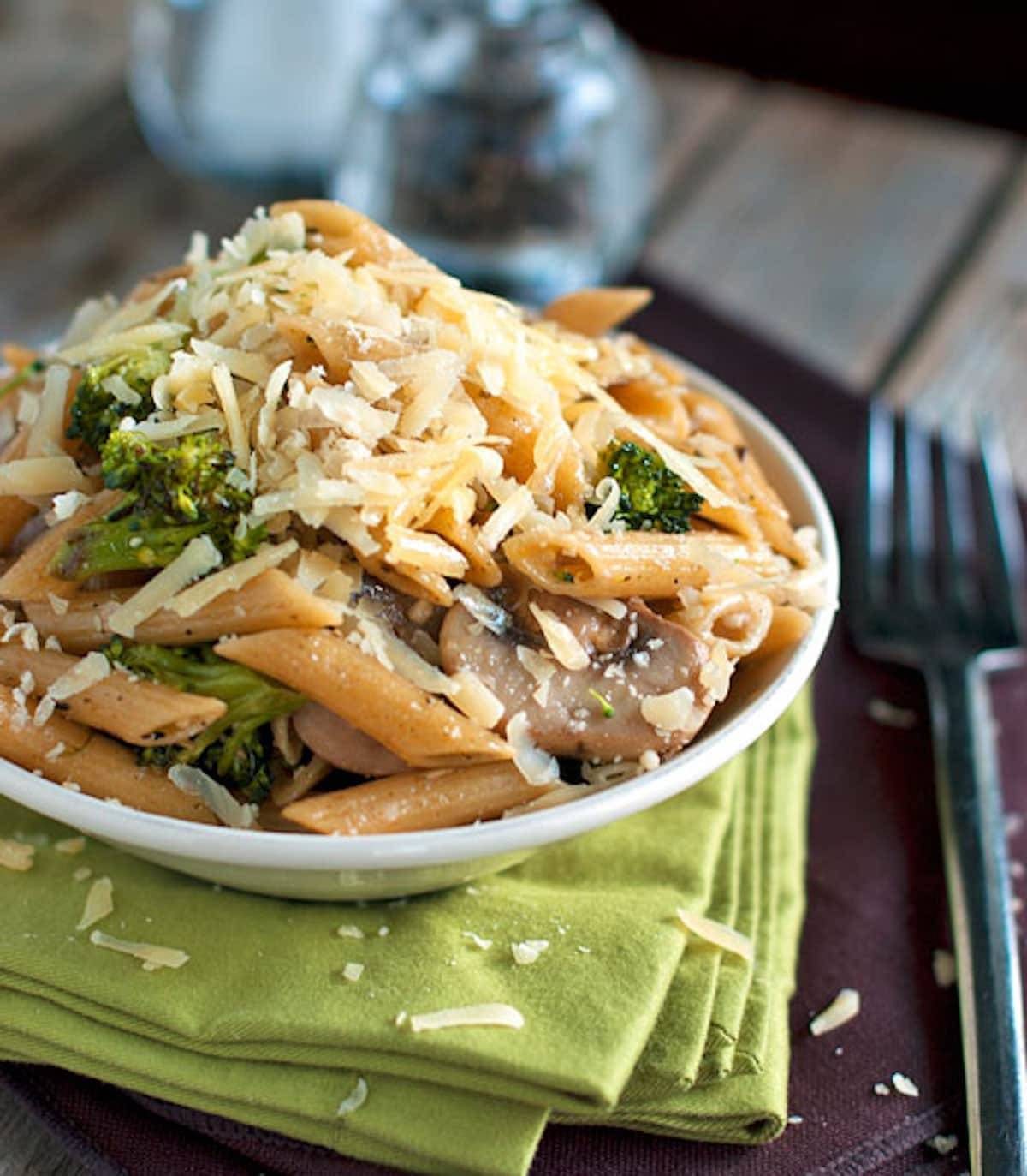 Rustic Garlic Butter Pasta topped with cheese in a bowl with a napkin.